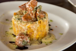 Mofongo dorado con chicharrones y ajo servido con caldo y cilantro